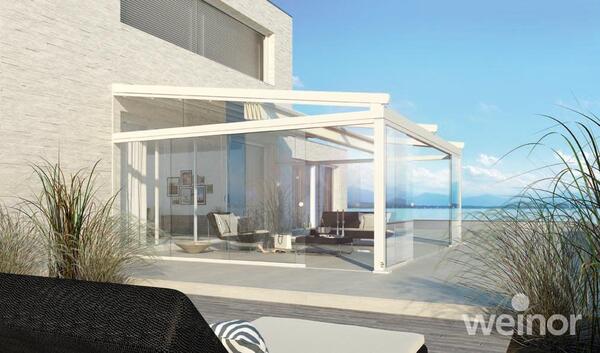 Modernes Terrassendach aus Glas an einem Haus mit Meerblick und stilvoller Terrasse.